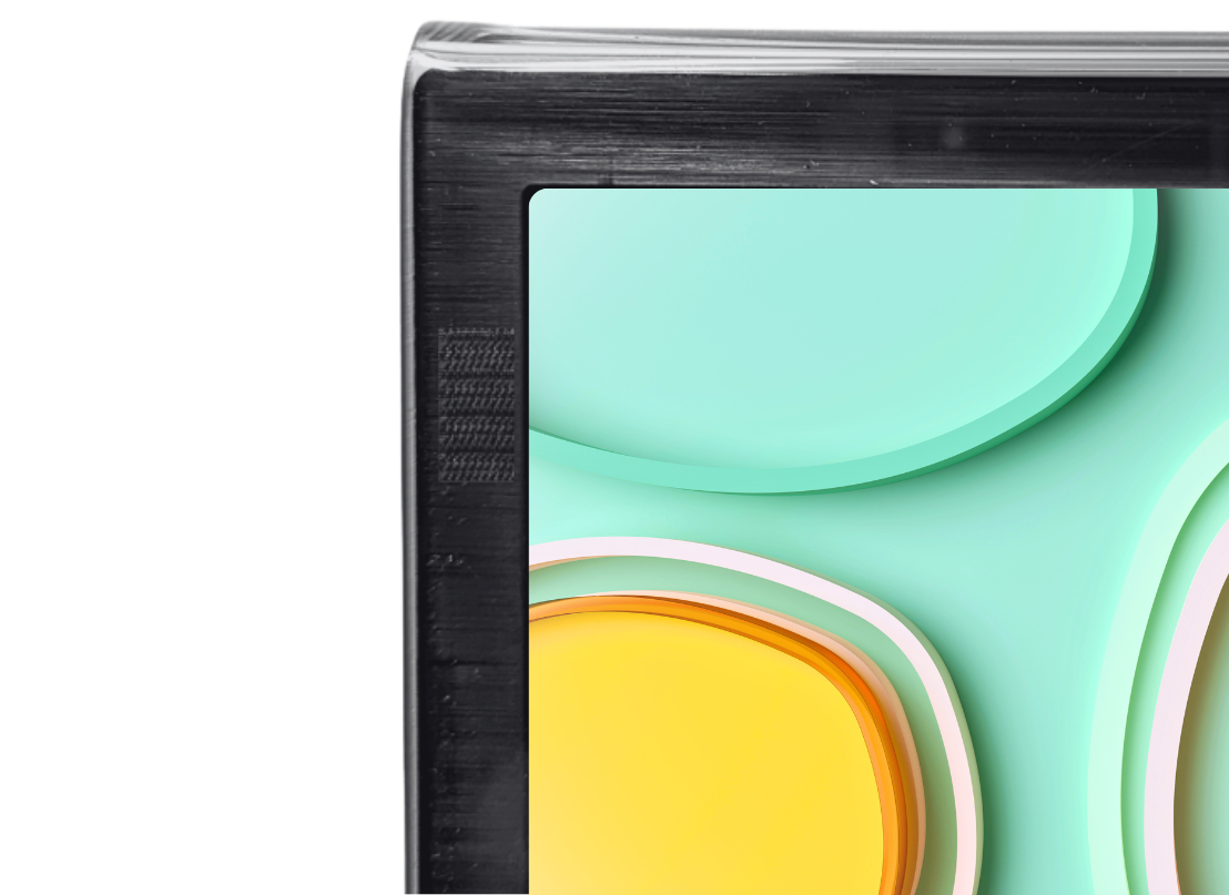 A close-up shows the top left corner of a flat-screen television with a clear screen protector slightly raised above the screen. The TV displays a portion of a colourful abstract image with teal and yellow shapes outlined in white and orange. The screen protector has a clean, rounded edge. The background is a dark grey and black checkerboard pattern.